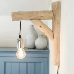 Wandleuchte aus entrindeten und halbierten Aststücken